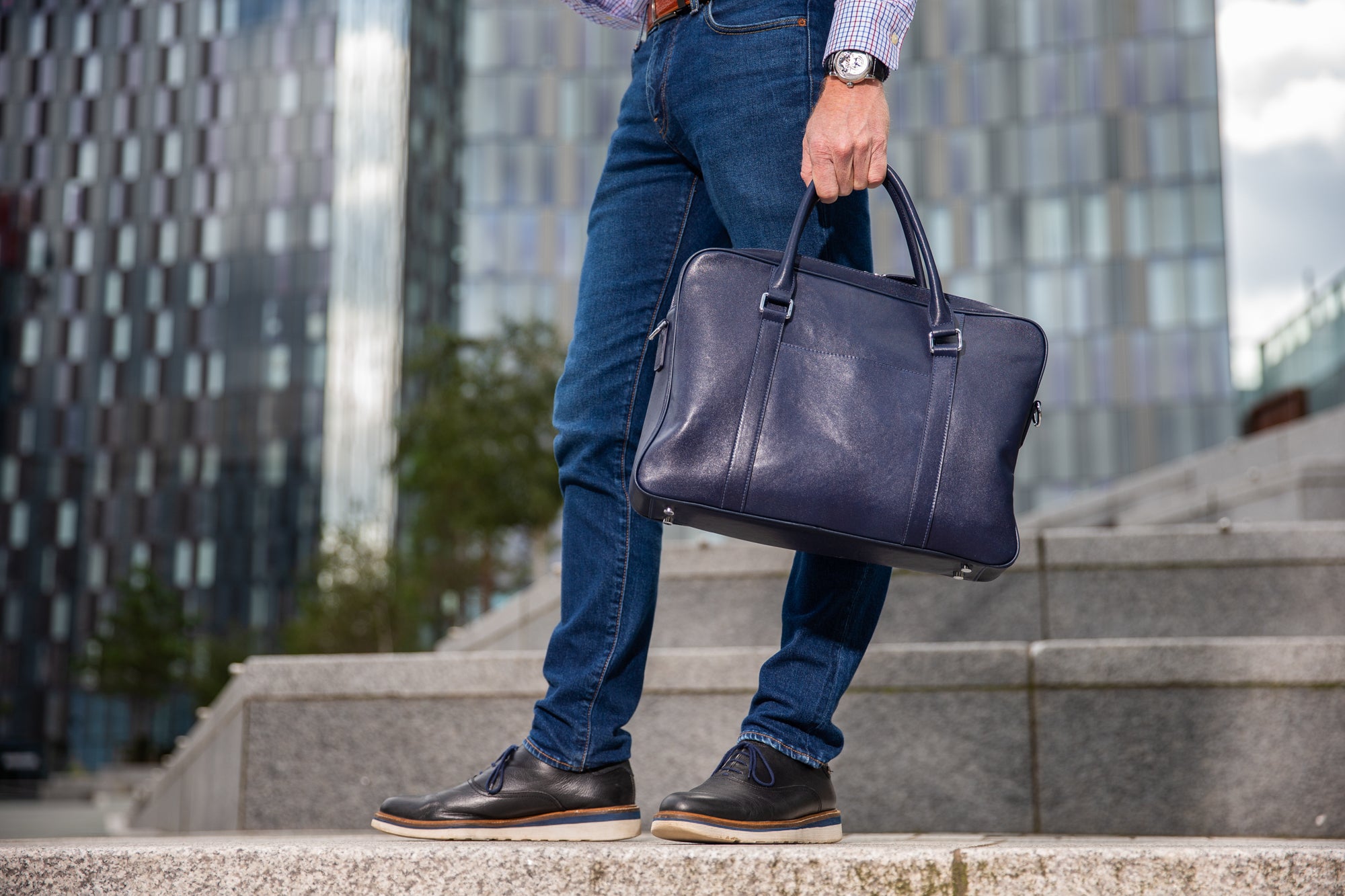 Lifestyle image on steps with blue leather laptop bag