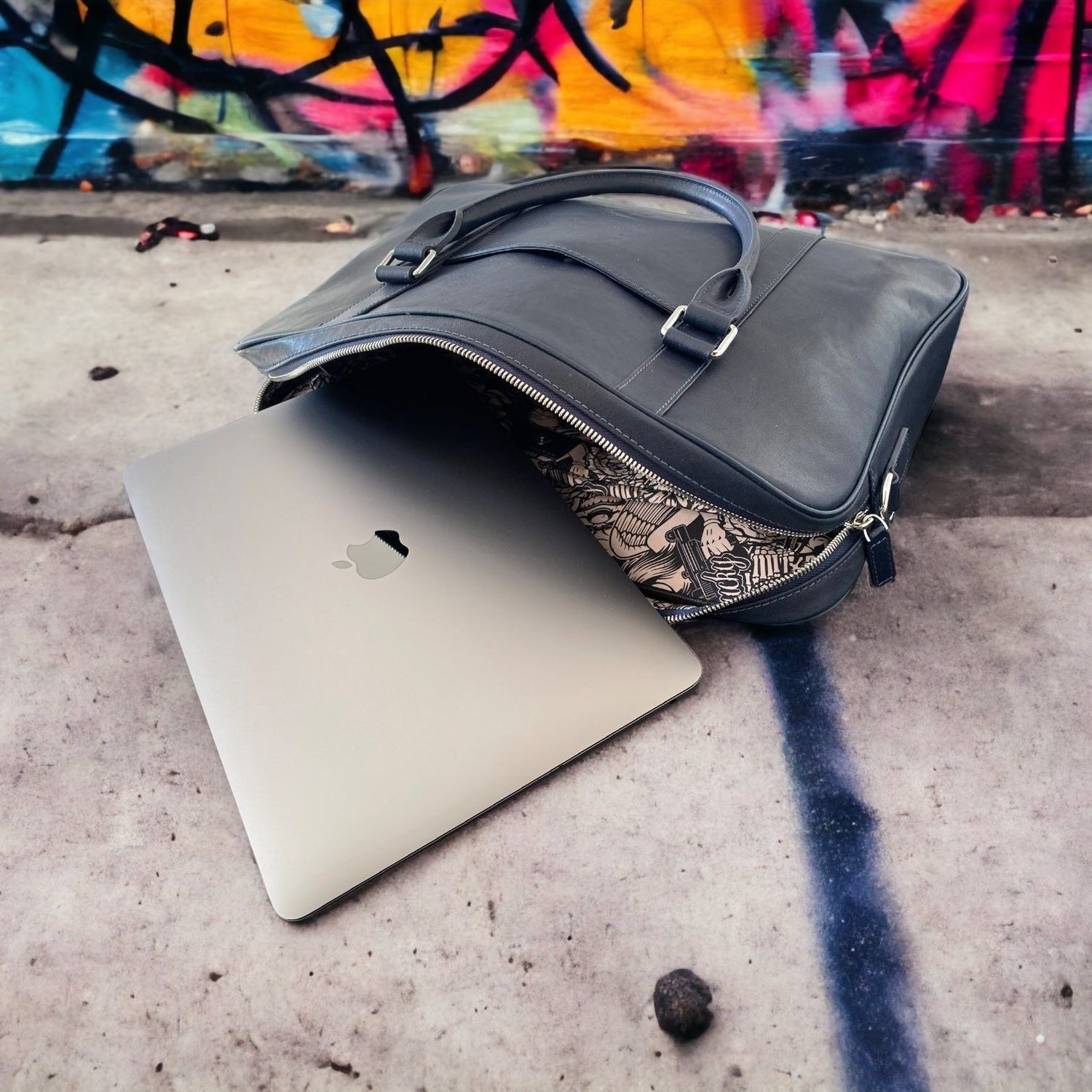 Leather Briefcase - lying on stone floor with laptop and graffiti backdrop - Colour Navy Blue - Funkin Class Leather Co.